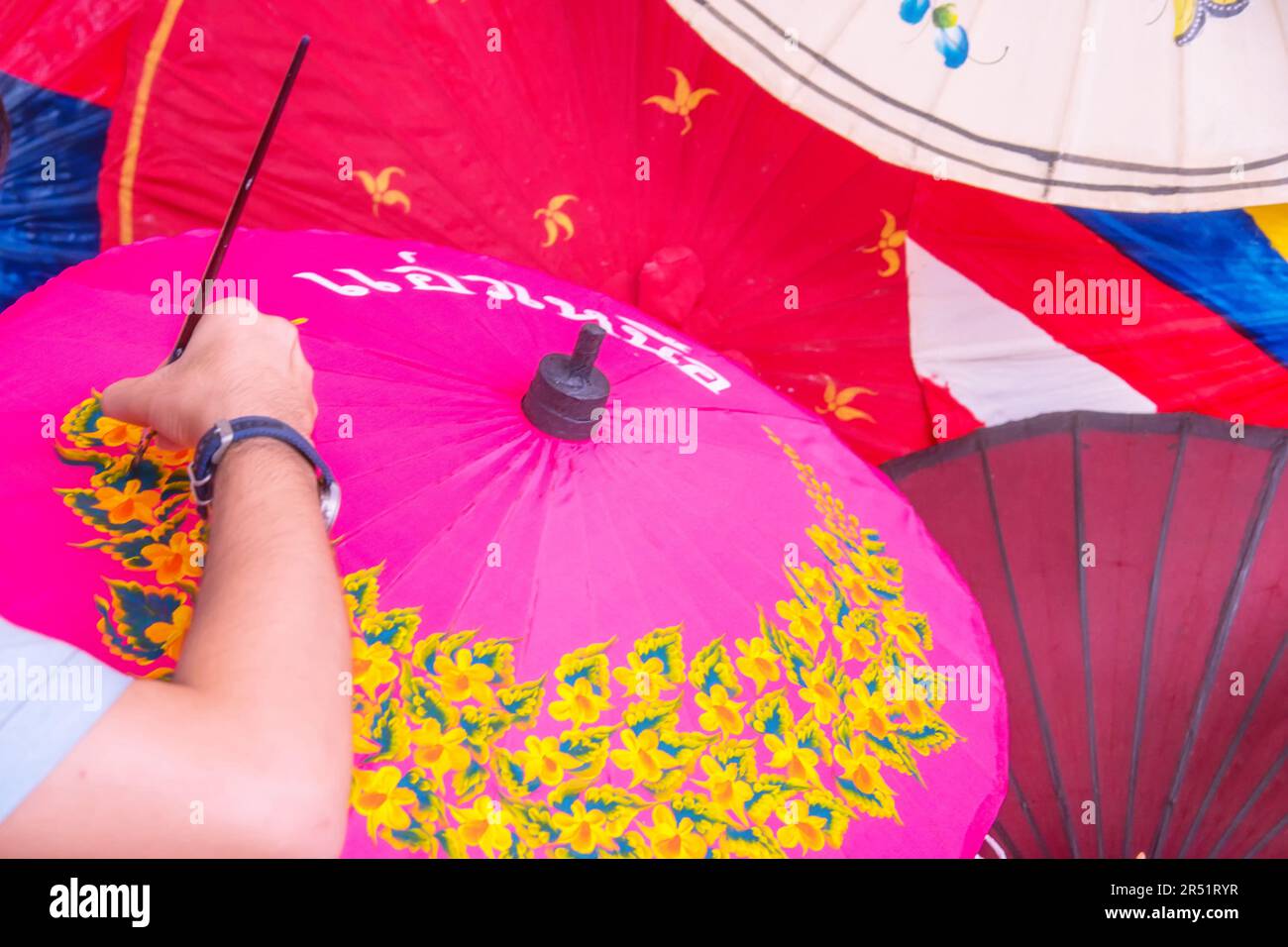 Uomo dipinto su ombrello fatto a mano del villaggio Bo Sang, Chiang mai, Thailandia. Foto Stock Uomo dipinto su ombrello fatto a mano del villaggio Bo Sang, Chiang mai, Thailandia. Foto Stock