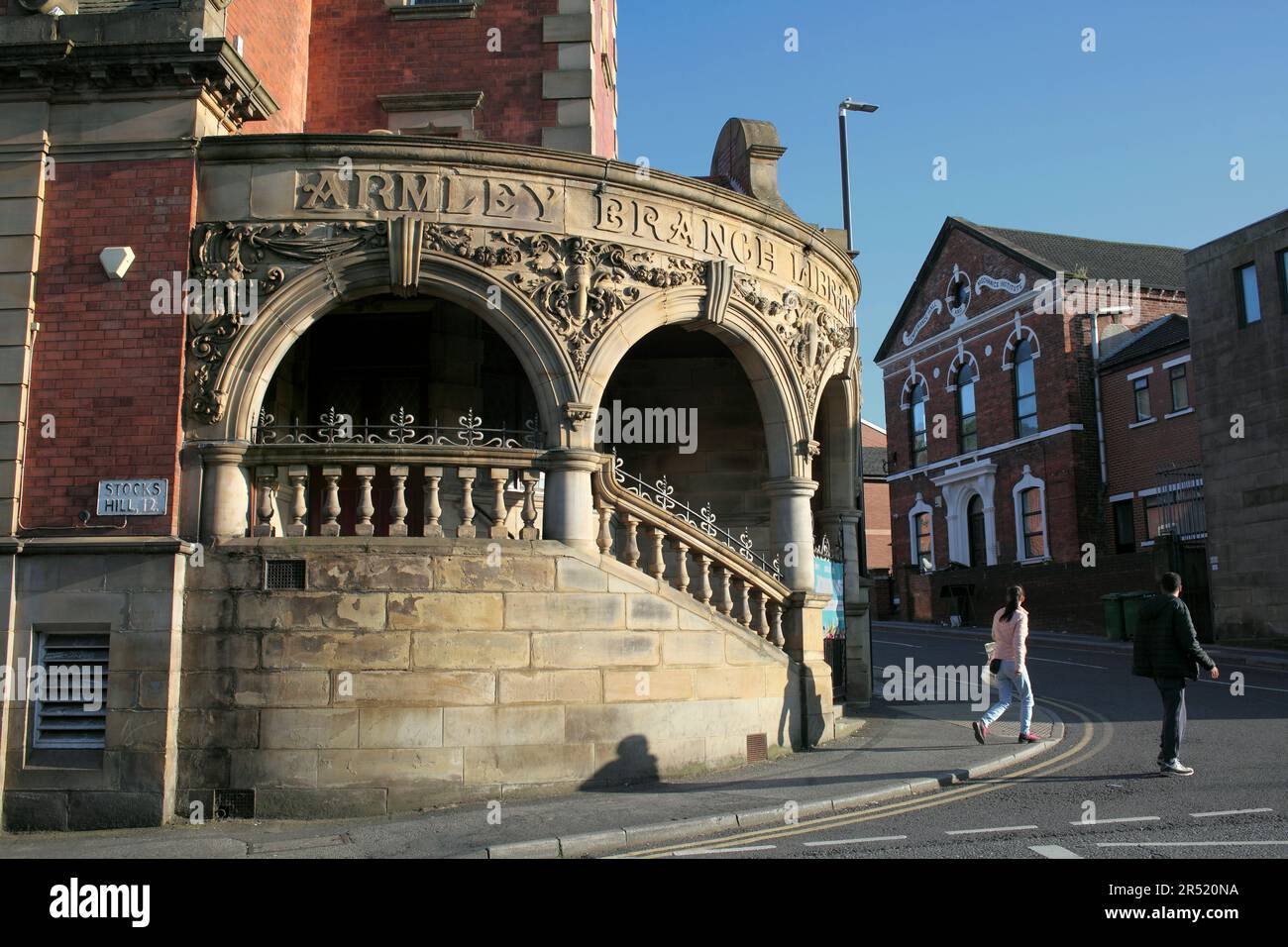 Il sole della tarda sera illumina l'ingresso della biblioteca di Armley Branch, Stocks Hill, Leeds. Foto Stock