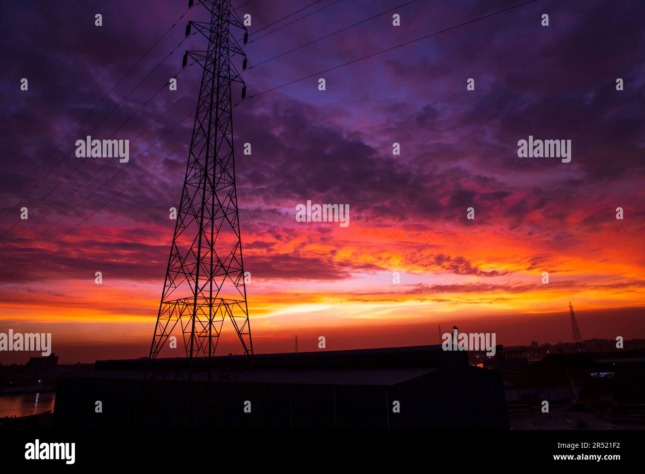 Torre della linea elettrica ad alta tensione con un bel cielo al tramonto, foto d'archivio Foto Stock