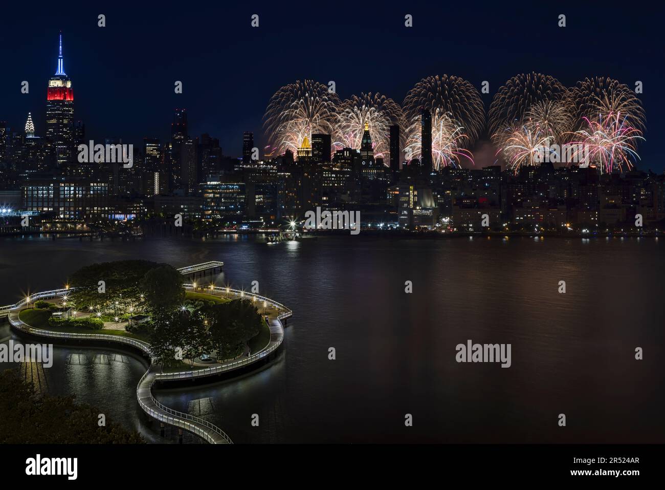 New York Skyline 4th luglio - veduta aerea del molo illuminato C di Hoboken, New Jersey e dell'Empire state Building nel centro di Manhattan, New York C. Foto Stock