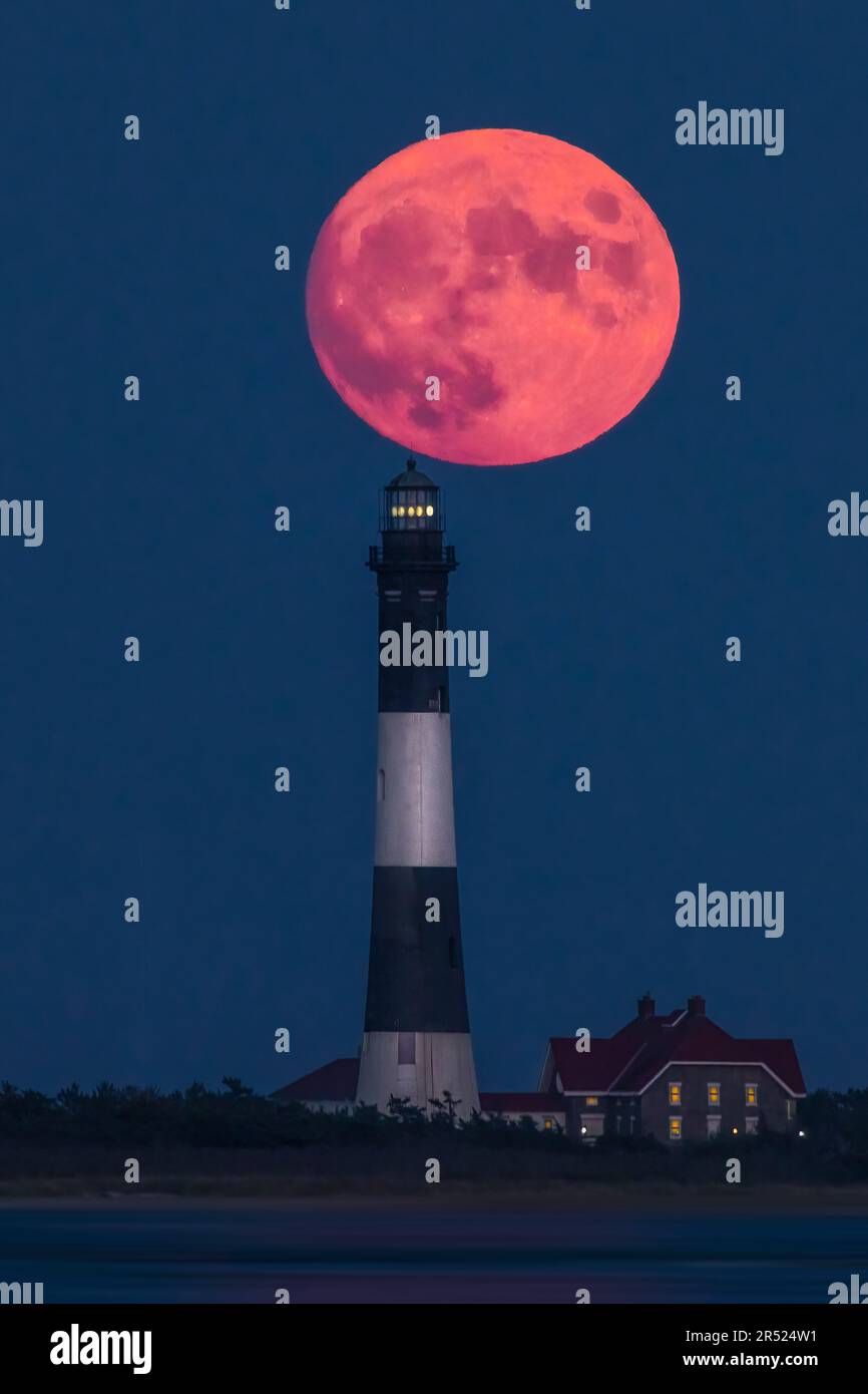 Faro di Fire Island Full Moon - la luna piena del raccolto si erge dietro il faro di Fire Island. Il faro di Fire Island è il faro più alto di lo Foto Stock