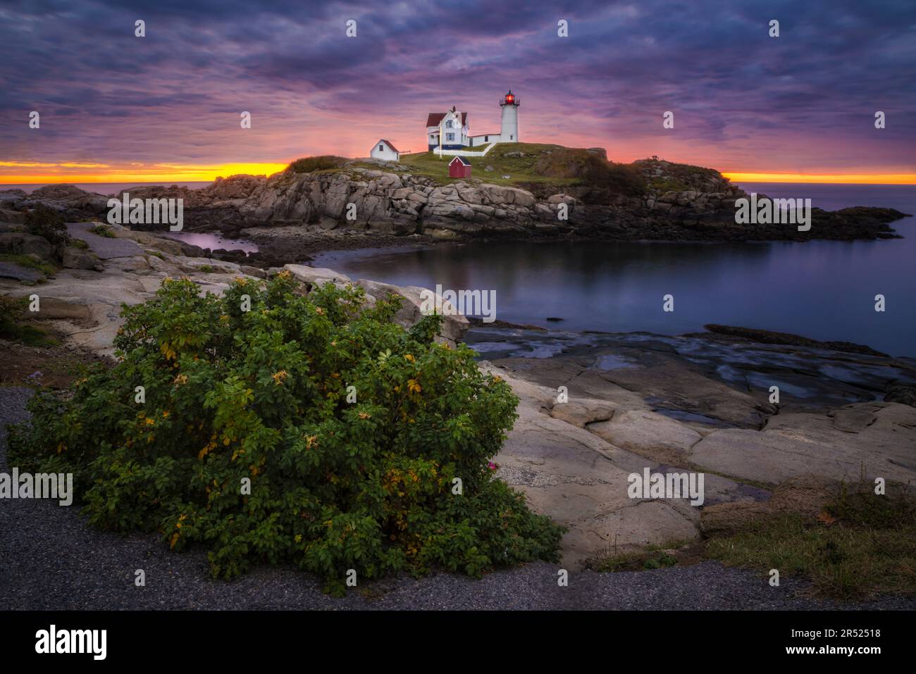 Nubble Light Sunrise ME - Vista di un bel cielo suggestivo con il sole che sorge dietro l'iconico faro di Nubble a Cape Neddick in Y Foto Stock