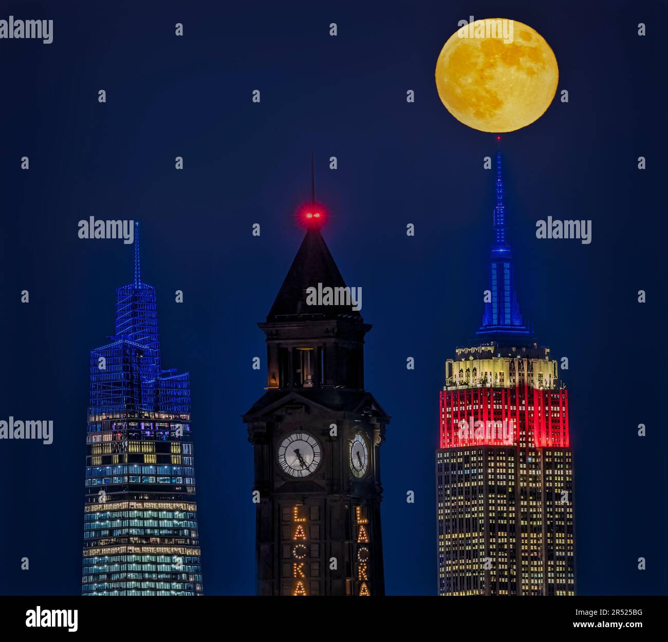 NJ NYC state Lines - la luna piena di Beaver sorge dietro la Torre dell'Orologio di Lackawanna a Hoboken, New Jersey, accanto all'iconico Empire state Building An Foto Stock