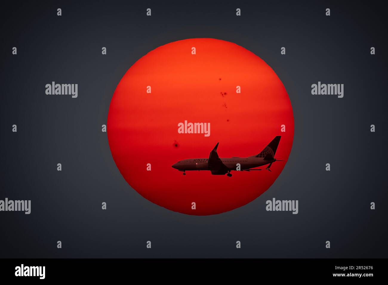 EWR Inbound Sunset - la discesa finale dell'aereo United Airlines è in arrivo a Newark NJ EWR e il sole che tramonta dietro di esso. Gli incendi boschivi canadesi Foto Stock