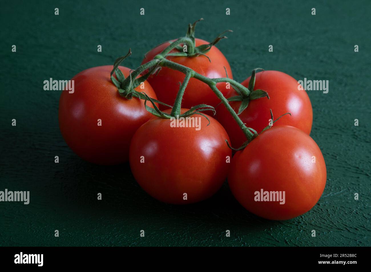 Un gruppo di pomodori d'uva su uno sfondo verde, vista dall'alto Foto Stock