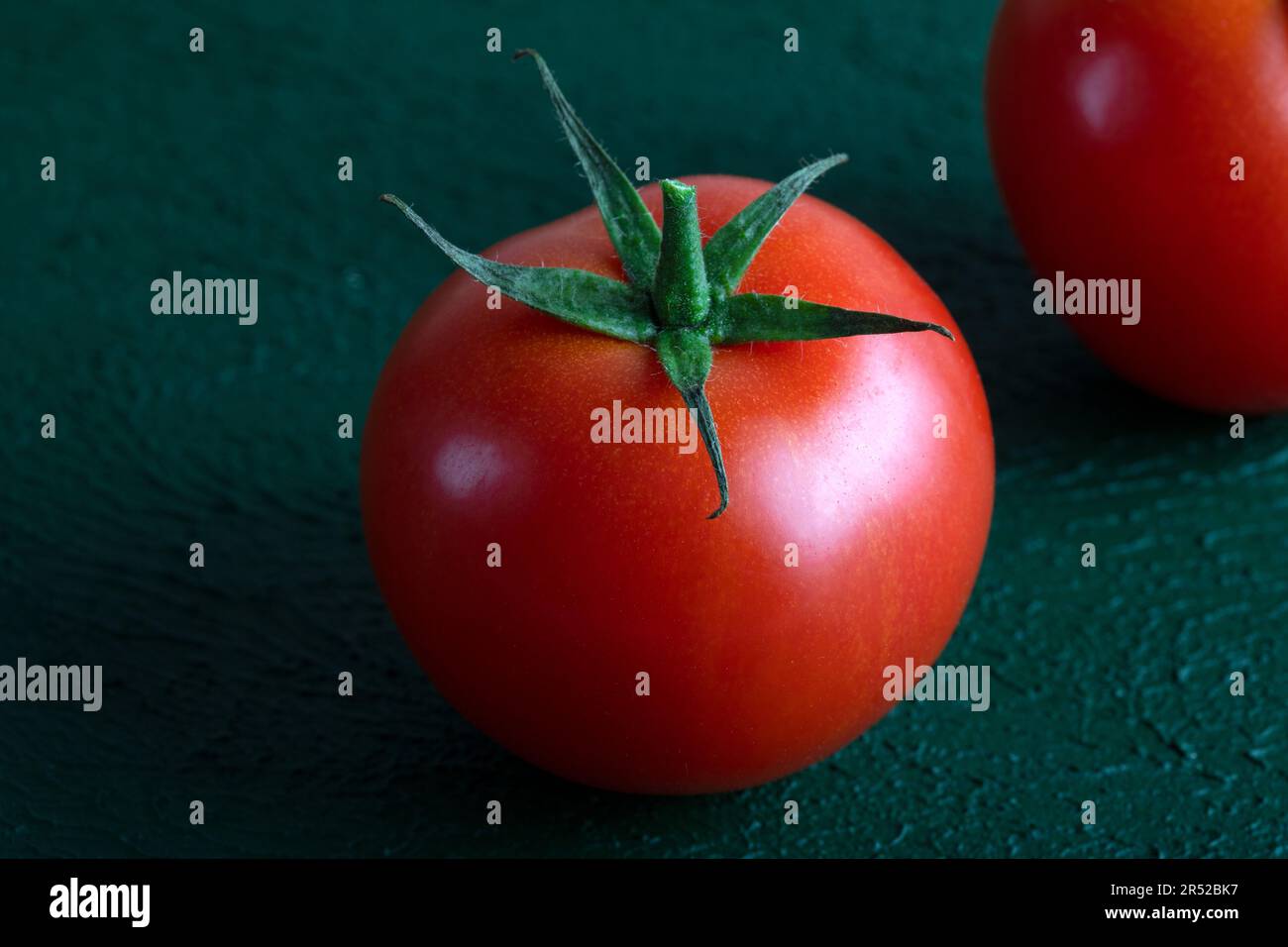 Pomodoro fresco d'uva su fondo verde, primo piano Foto Stock