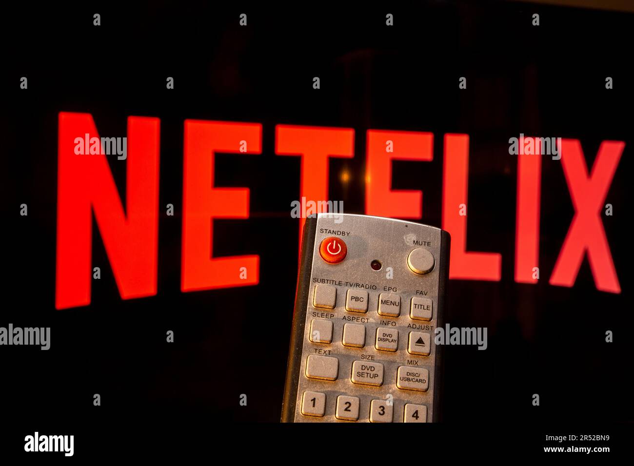 Telecomando davanti a un televisore sul quale è possibile visualizzare il logo Netflix (immagine simbolo) Foto Stock