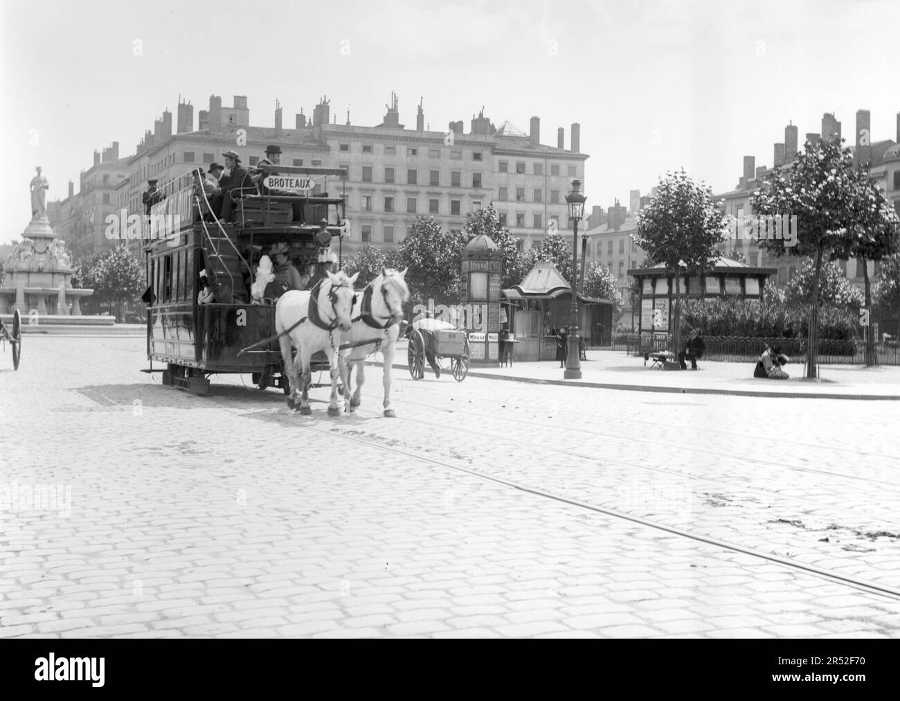 Una carrozza trainata da cavalli attraversa un luogo nella città di Lione, all'inizio del 20th ° secolo. Si tratta di una vecchia foto digitalizzata da lastre di vetro. Foto Stock