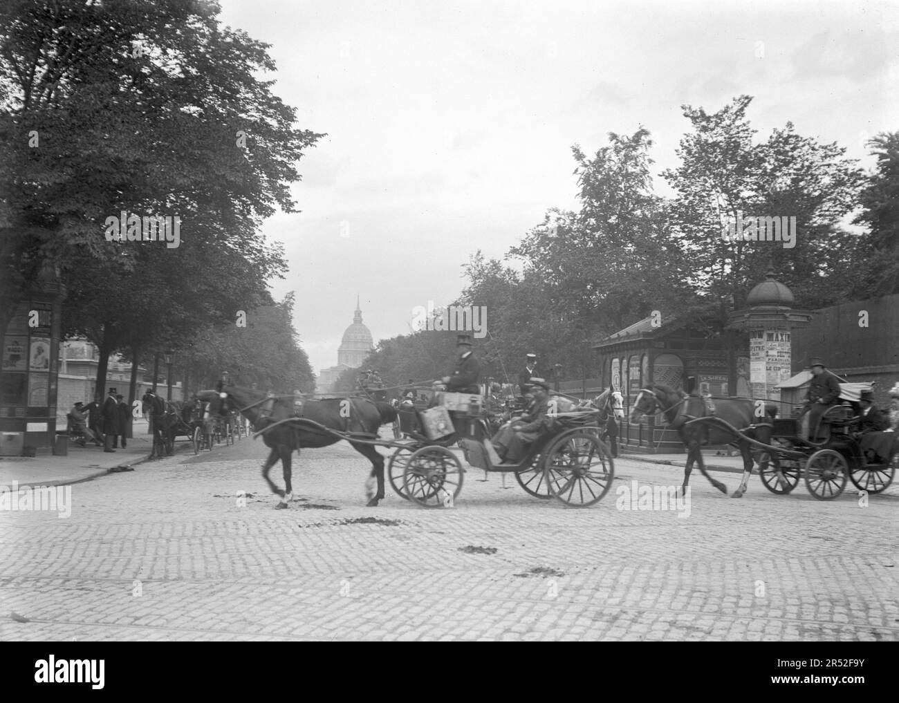 Una carrozza trainata da cavalli attraversa una strada a Parigi. C'è Les Invalides in background. Inizio del 20th ° secolo. Vecchia fotografia digitalizzata. Foto Stock