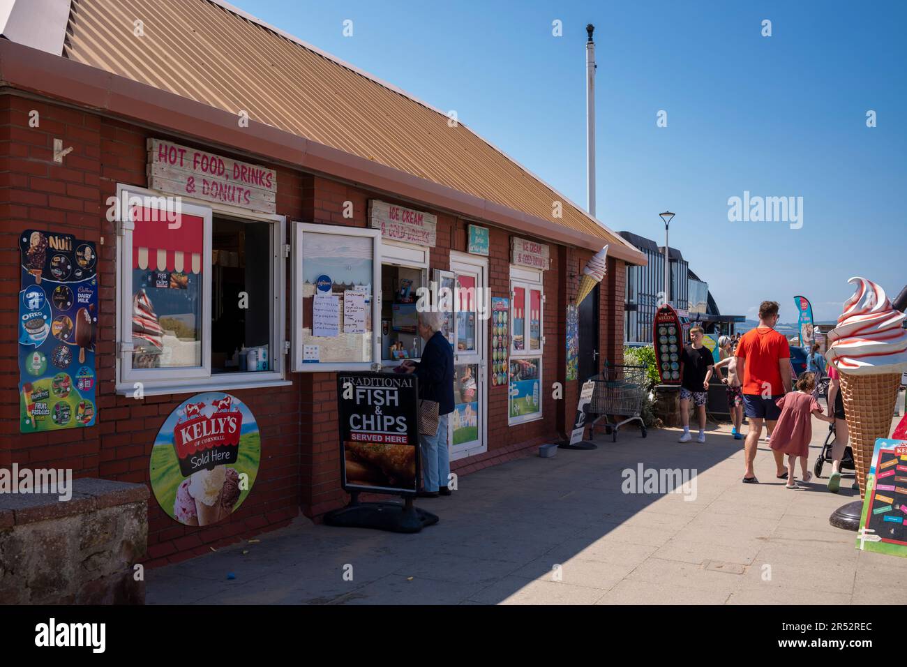 Persone che acquistano e mangiano gelato a West Kirby Beach Foto Stock