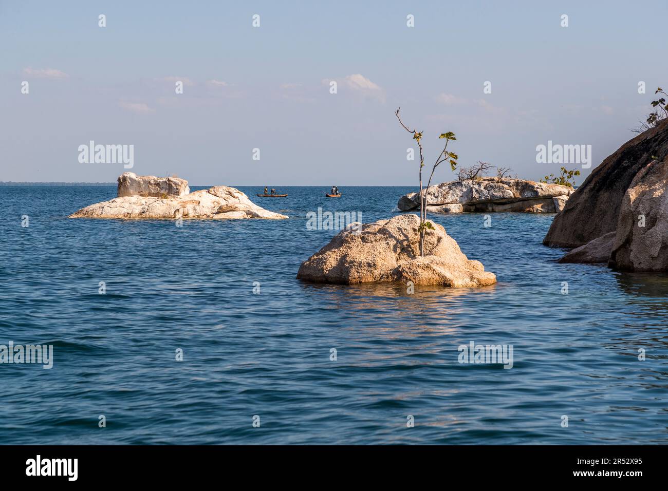 Due piccole barche da pesca galleggiano tra rocce pallide modellate dalle onde a Otter Point, Cape Maclear, Malawi. Foto Stock