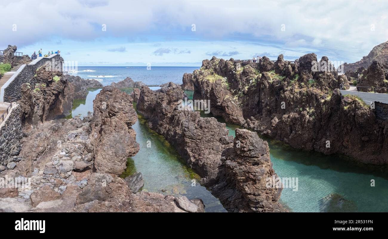 Isola di Madeira Portogallo - 04 19 2023: Vista panoramica delle piscine naturali sul villaggio di Porto Moniz, formata da rocce vulcaniche, isoletta di Mole nella ba Foto Stock