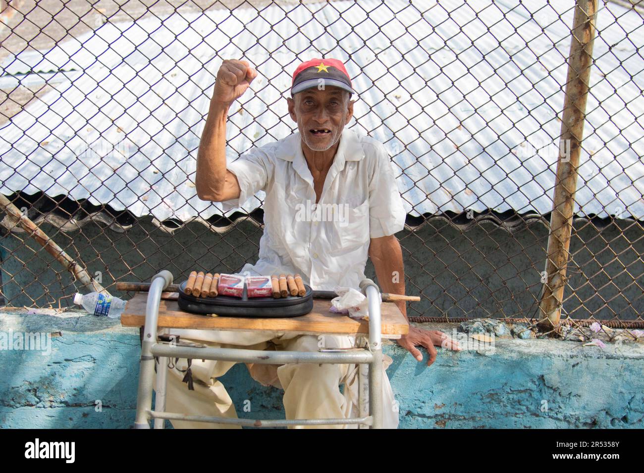 L'uomo più anziano sorride mentre vende sigarette e sigari in un piccolo negozio di fronte a l'Avana, Cuba. Foto Stock