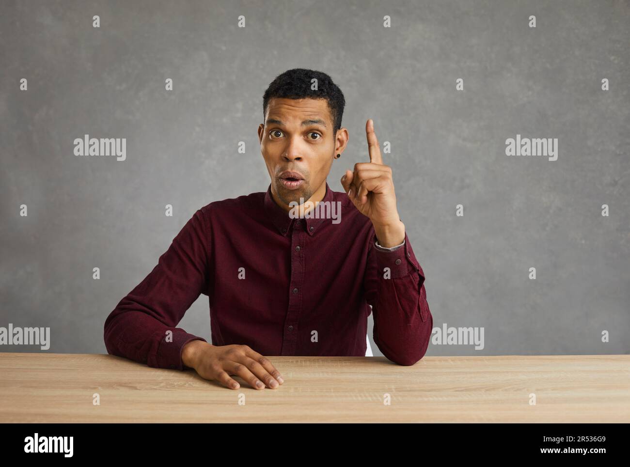 Uomo dalla pelle scura che ha una grande idea innovativa puntando il dito sul segno di eureka. Foto Stock