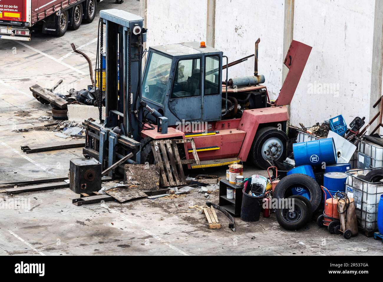 Barcellona, Spagna - 17 aprile 2023: Rottami di metallo e un carrello o carrello elevatore a forche rotto presso il molo di carico del porto di Barcellona, Catalogna, Spagna Foto Stock