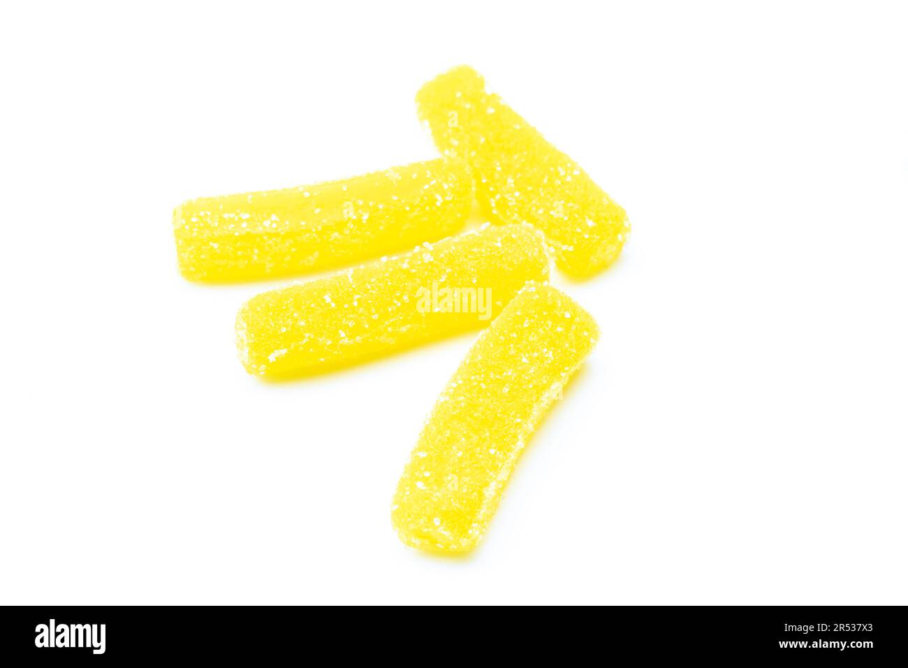 Mucchio di caramelle di gelatina zuccherate gialle isolate su sfondo bianco. I vermi gommosi curano Foto Stock