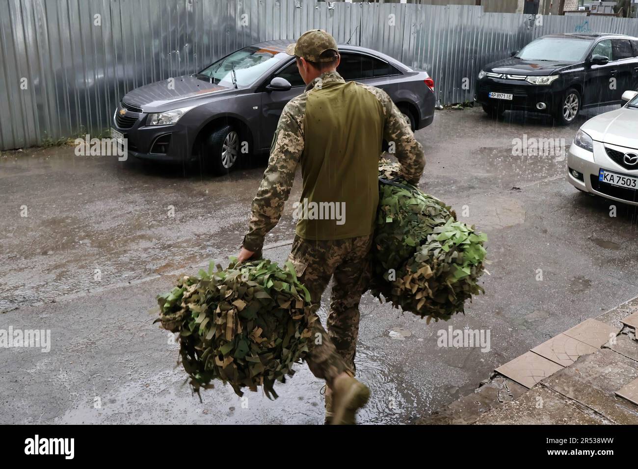 Zaporizhzhzhia, Ucraina. 30th maggio, 2023. Un soldato dell'esercito ucraino è visto con una rete di mimetizzazione che sono stati fatti in un centro volontario a Zaporizhzhzhia. Dal primo giorno di guerra Zaporizhzhzhia è diventato un alveare di attività per i volontari che producono tutto da armatura corpo a reti mimetizzazione, ostacoli anticarro a stufe di riscaldamento e imbragature per fucili per i soldati ucraini che combattono l'invasione russa. (Credit Image: © Andriy Andriyenko/SOPA Images via ZUMA Press Wire) SOLO PER USO EDITORIALE! Non per USO commerciale! Foto Stock