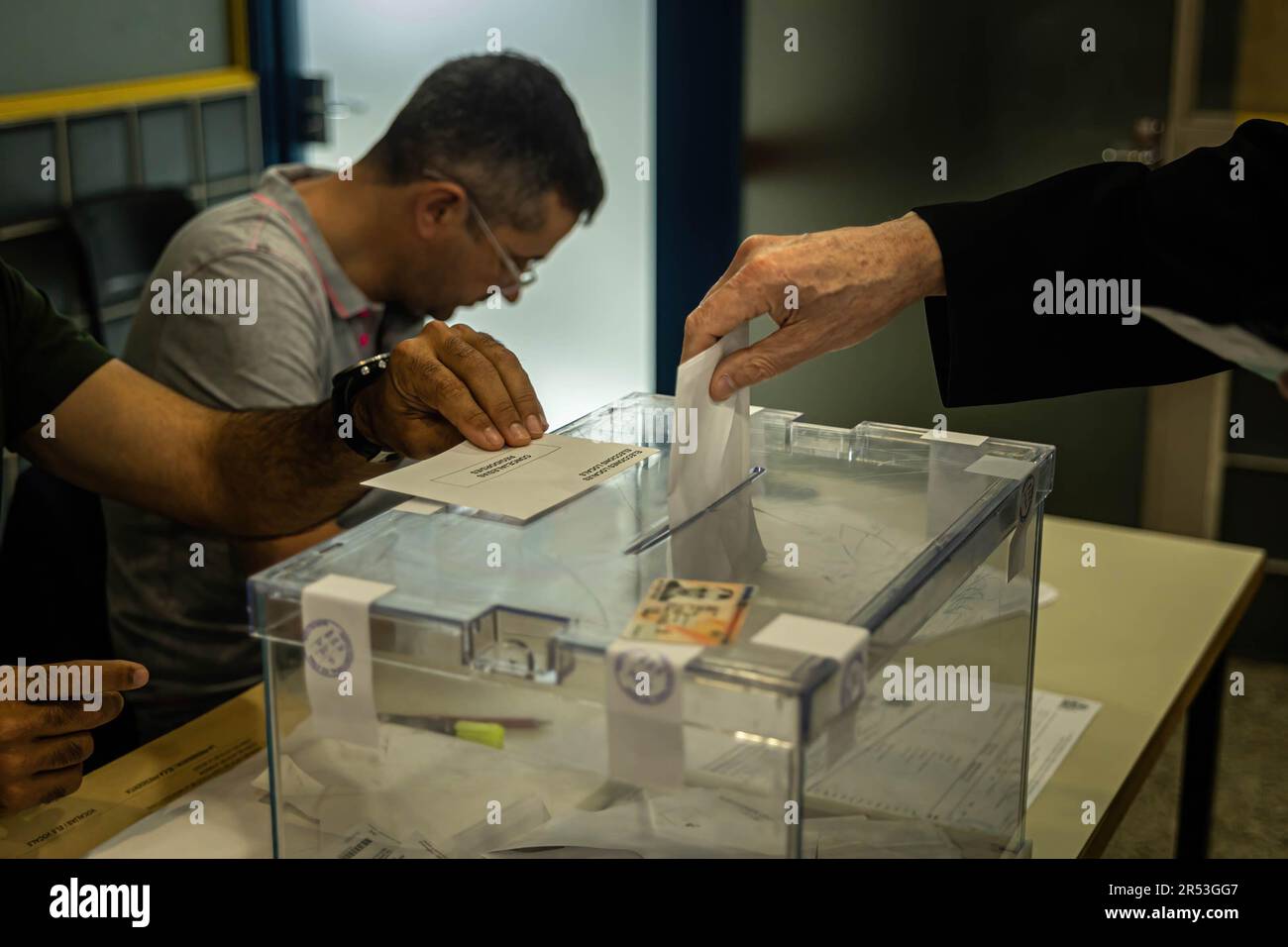 Un elettore lancia il suo voto al di fuori di uno dei seggi elettorali. La celebrazione delle elezioni comunali a Barcellona, che segna l'elezione del nuovo sindaco. Foto Stock
