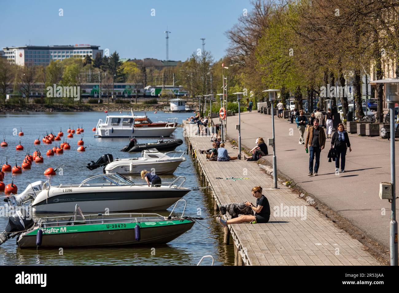 Persone a Pitkänsillanranta in una calda giornata primaverile nel quartiere Siltasaari di Helsinki, Finlandia Foto Stock