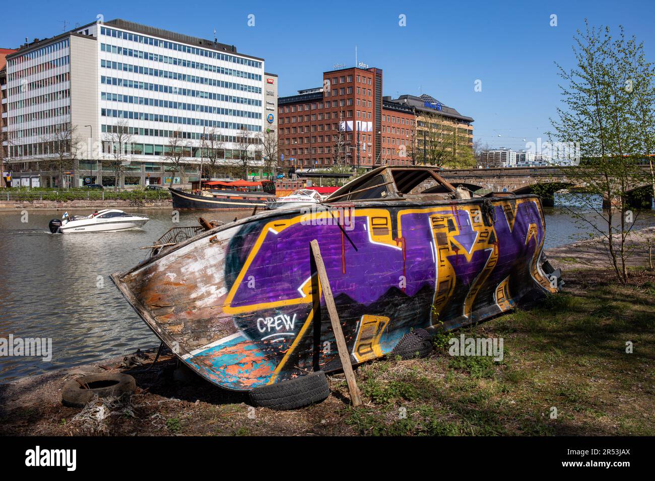 Barca in legno abbandonata, derelitta, coperta da graffiti marciante a Kaisaniemenranta, nel quartiere Kaisaniemi di Helsinki, Finlandia Foto Stock