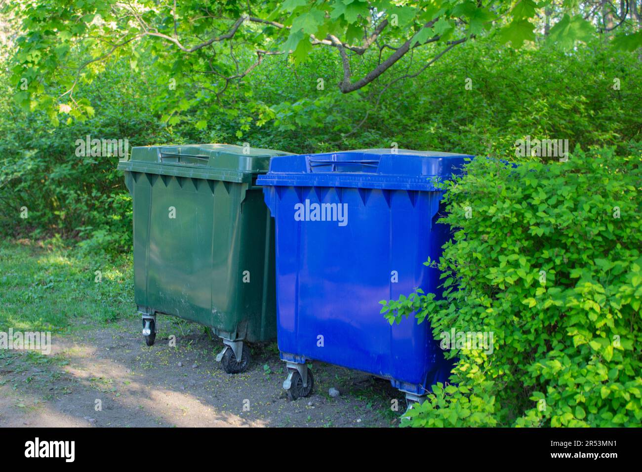 Due contenitori per rifiuti in plastica. I container si trovano nel parco cittadino. Smistamento separato dei rifiuti. Atteggiamento responsabile nei confronti dell'ambiente. Zero wa Foto Stock
