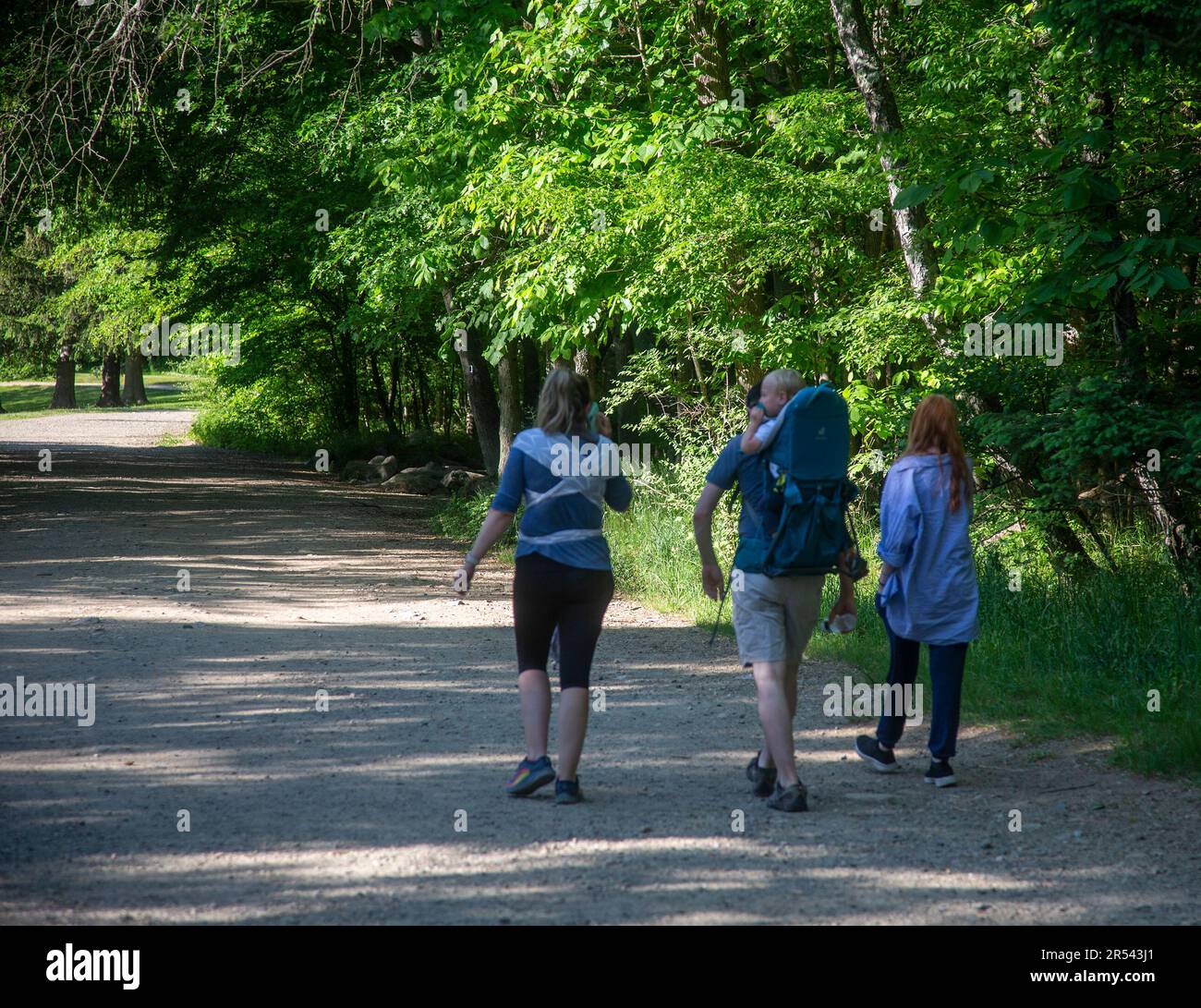 Gruppo di persone che camminano lungo un sentiero con un bambino in un vettore Foto Stock