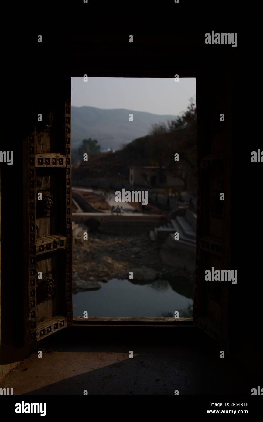Vignette divine: Scene della finestra del tempio indù a katas Raj, Punjab, Pakistan Foto Stock