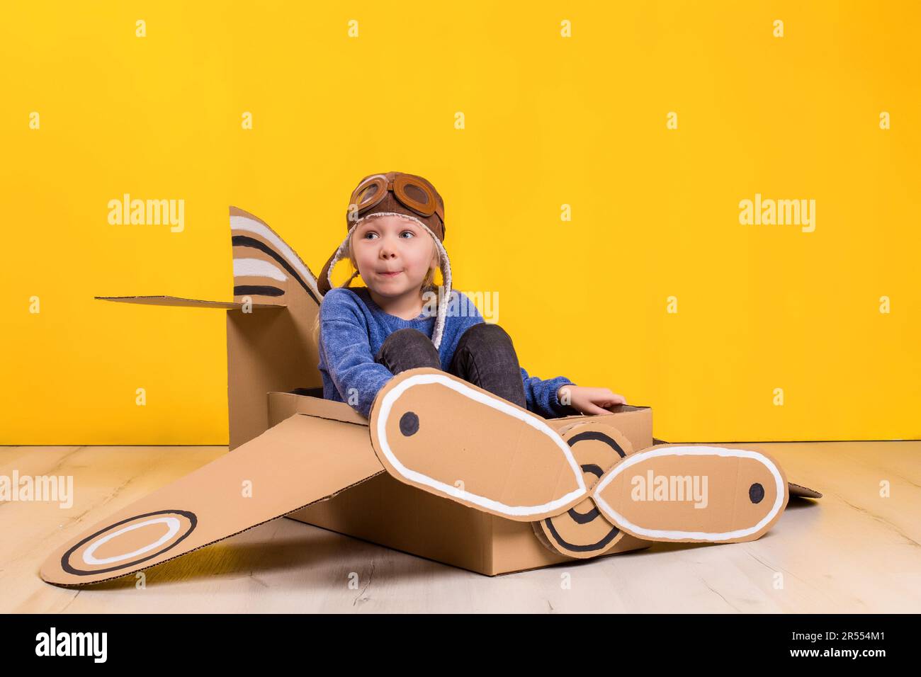 Bambina sognatrice che gioca con un aereo di cartone. Infanzia. Fantasia,  immaginazione Foto stock - Alamy