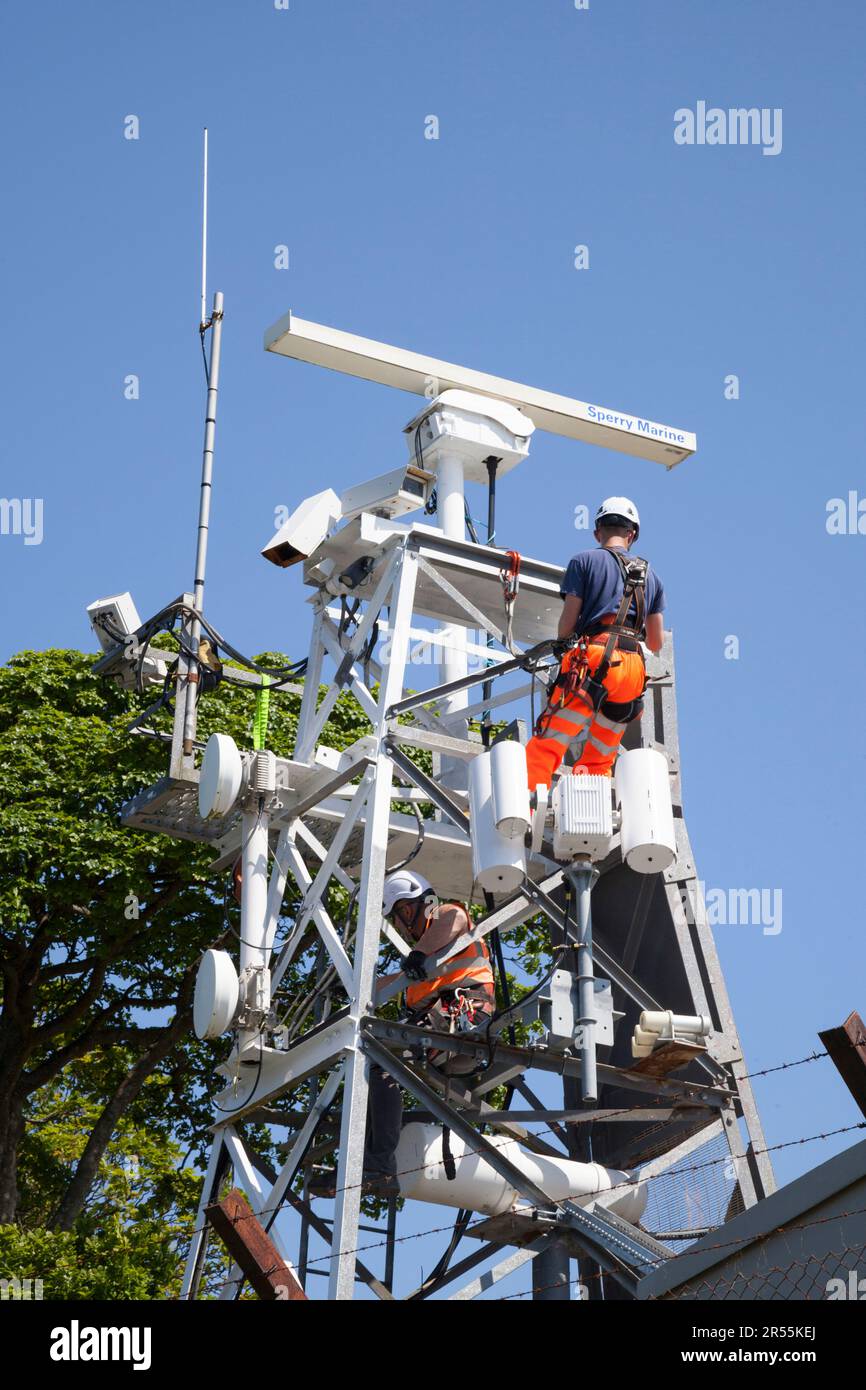 Uomini dipingere come parte della manutenzione di attrezzature marine, Rhu, Scozia Foto Stock