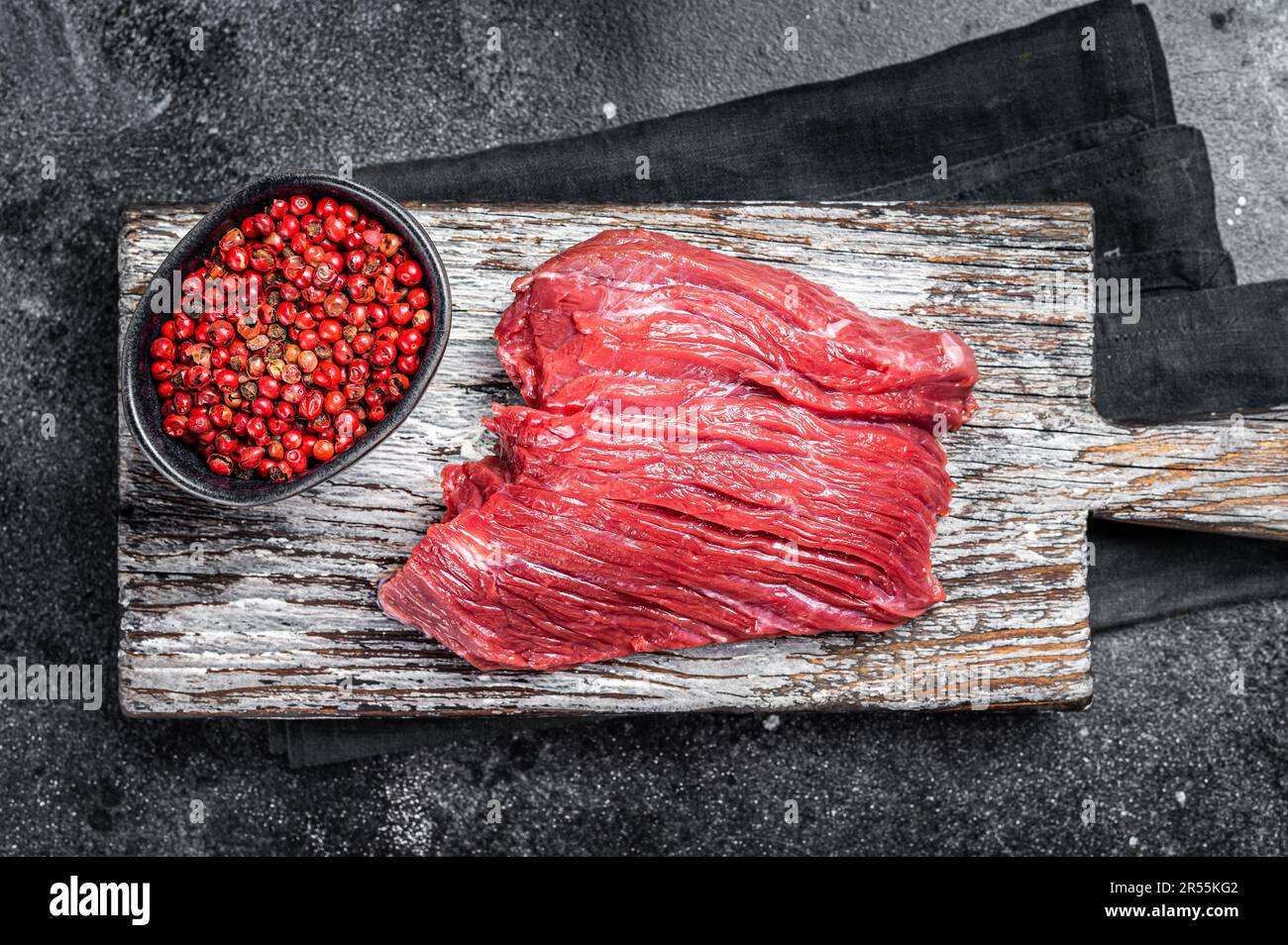 Selvaggina cruda cara bistecca pronta per la cottura. Sfondo nero. Vista dall'alto. Foto Stock