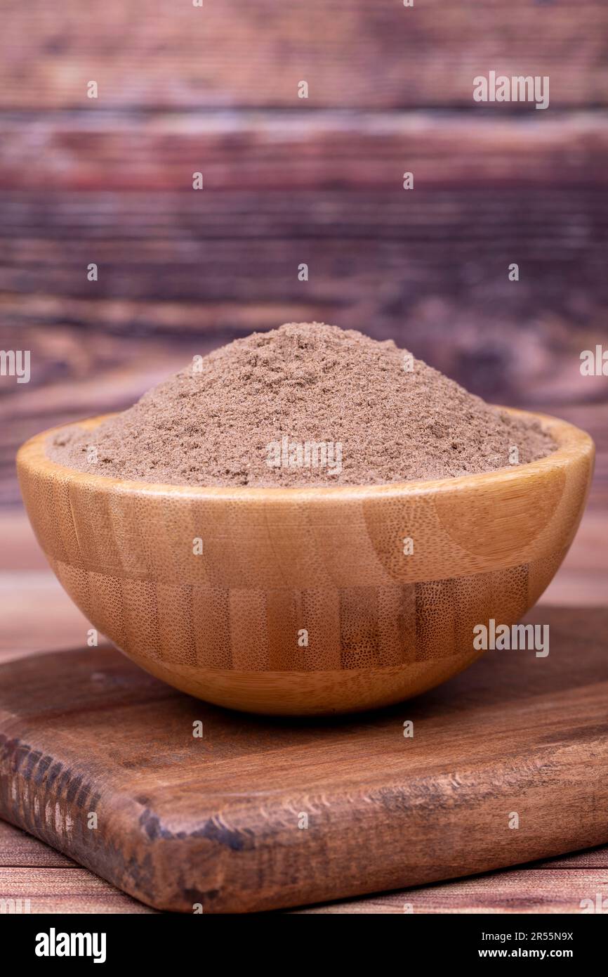 Spezie in polvere su sfondo di legno. Spice di legno essiccato in polvere. Spezie Pimento, pepe giamaicano e trucioli Foto Stock