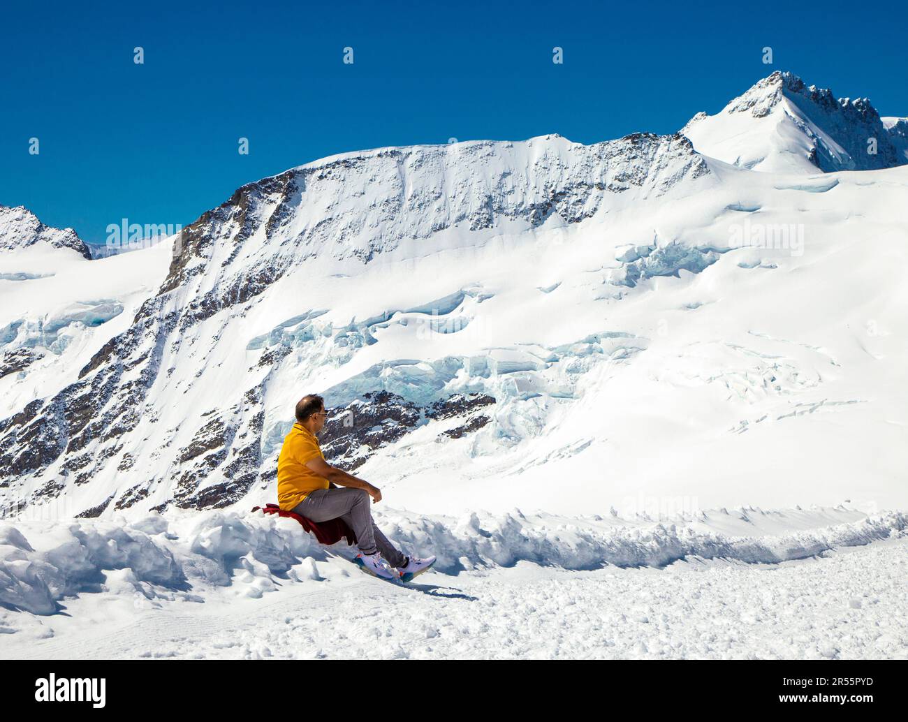 Uomo che gode di vista sulle montagne lungo il sentiero escursionistico dalla cima della Jungfrau al rifugio Mönchsjoch, Kranzberg sullo sfondo, Alpi, Svizzera Foto Stock
