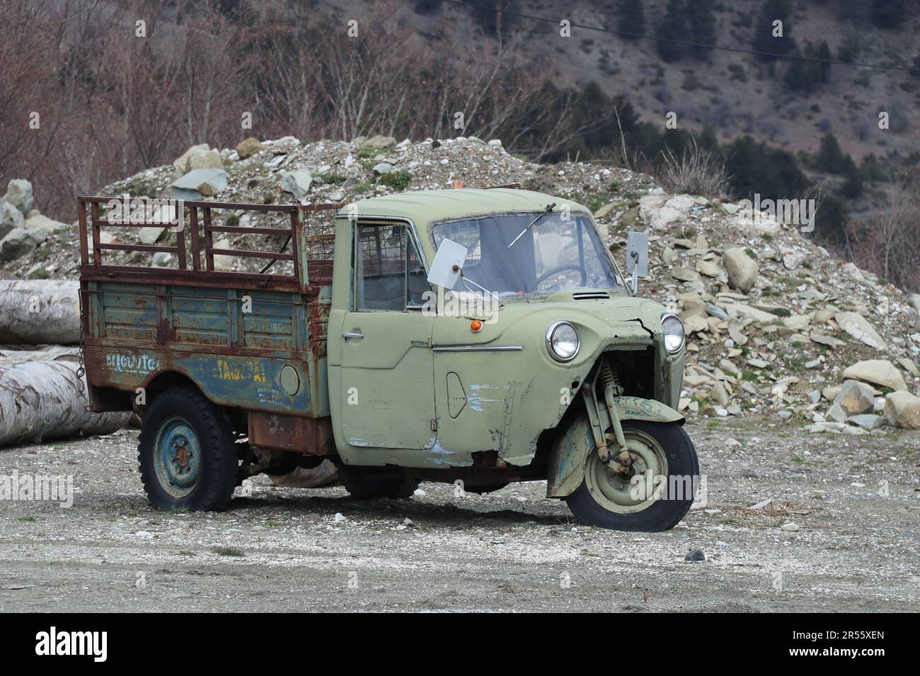 Grüner Dreirad Old Timer Transporter vor Schotterhaufen Foto Stock