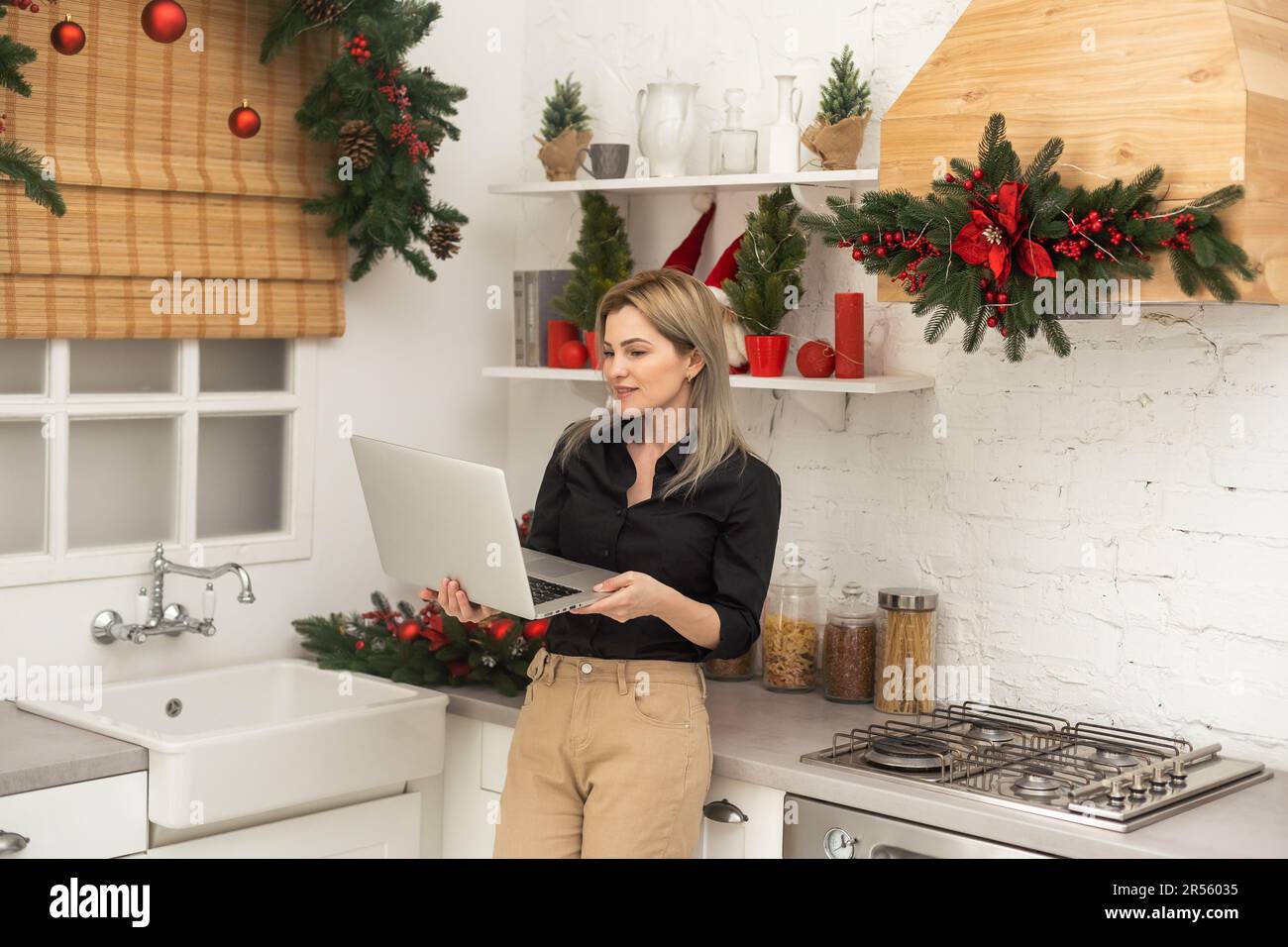 Donna d'affari che lavora su un computer portatile durante le festività natalizie, digitando sulla tastiera del computer. Natale sul lavoro Foto Stock