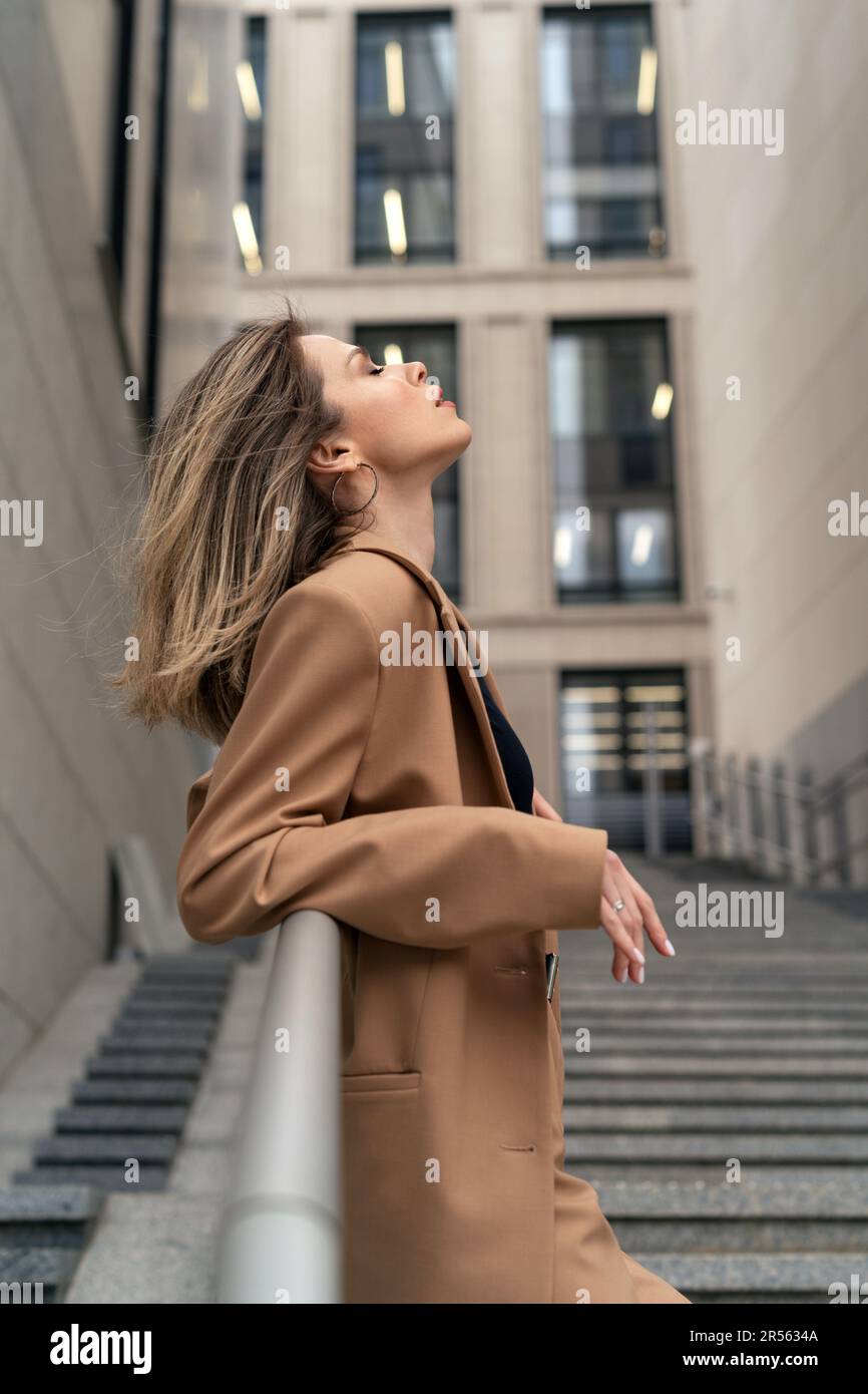 Ritratto di una donna d'affari in vestito pant in piedi su gradini fuori un edificio, Bielorussia Foto Stock