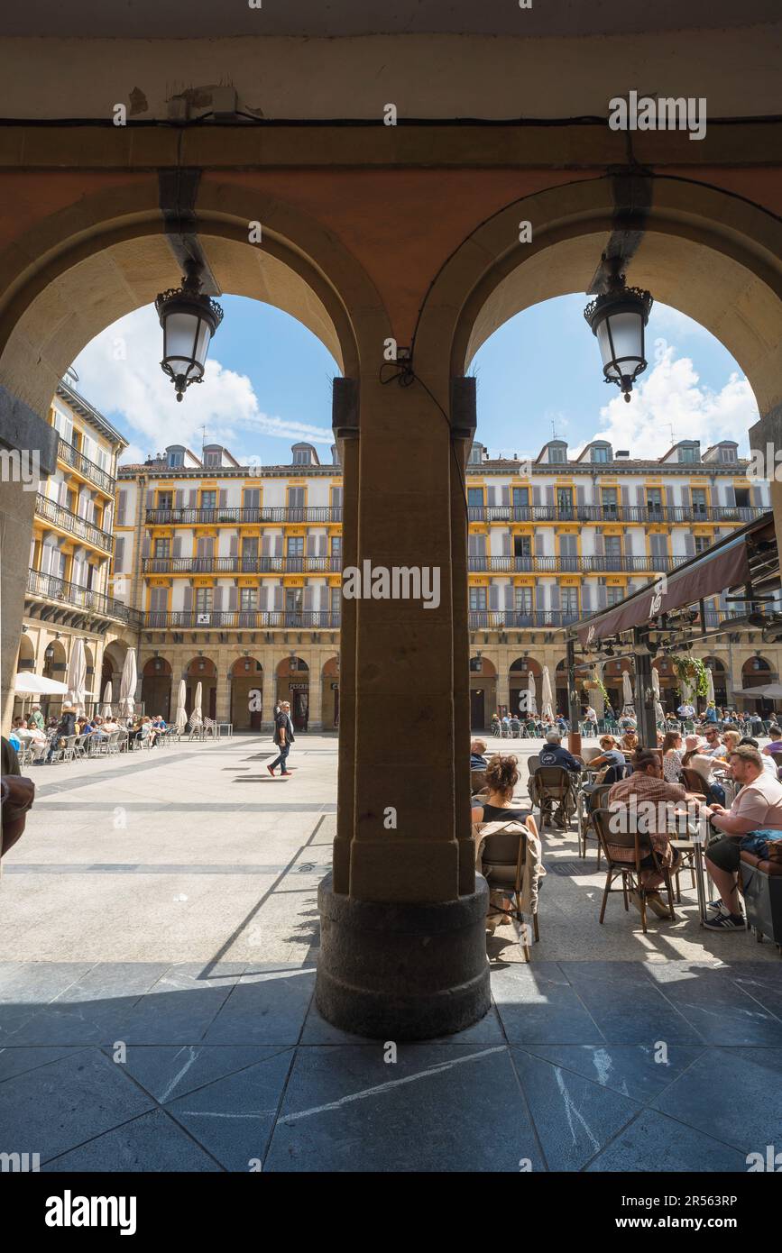 San Sebastian Plaza Constitucion, ammira in estate le persone che si rilassano ai tavoli dei caffè all'interno della Plaza de la Constitucion nella città vecchia di San Sebastian. Foto Stock