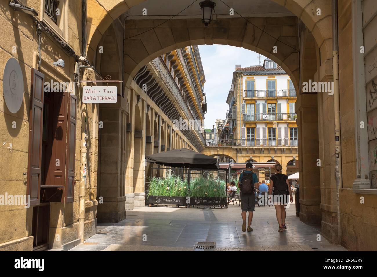 Città vecchia di San Sebastian, vista delle persone che camminano in Plaza de la Constitucion, una piazza storica situata nel centro del pittoresco quartiere della città vecchia. Foto Stock