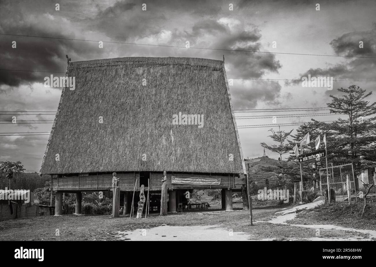 Una tradizionale 'nha rong', o casa culturale, con il suo alto tetto in paglia simile a vela, appartenente alla minoranza etnica Bahnar vicino al villaggio Foto Stock
