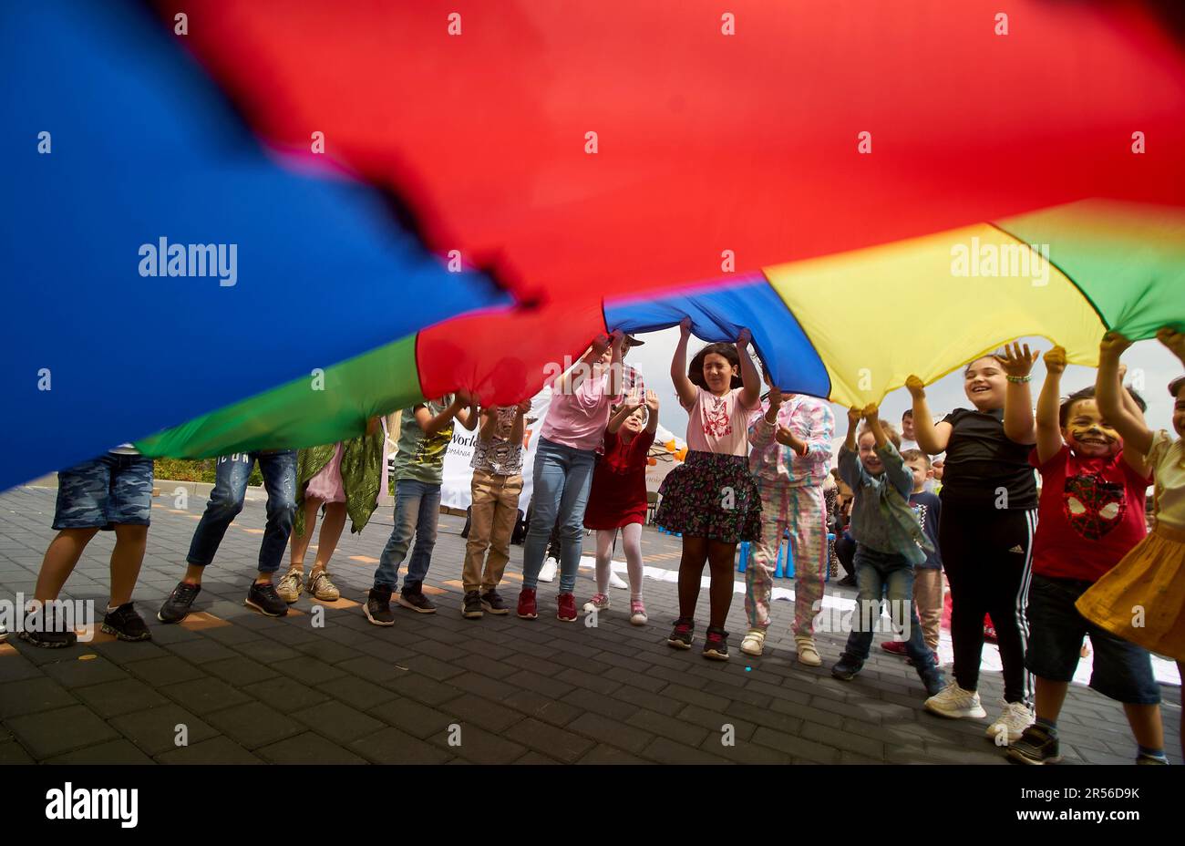 Bucarest, Romania. 1st giugno 2023: I bambini giocano con una bandiera colorata nel cortile del Palazzo del Parlamento, dove il Senato rumeno ha aperto le sue porte in occasione della Giornata dei bambini e ha organizzato varie attività per intrattenerli. Credit: Lucian Alecu/Alamy Live News Foto Stock