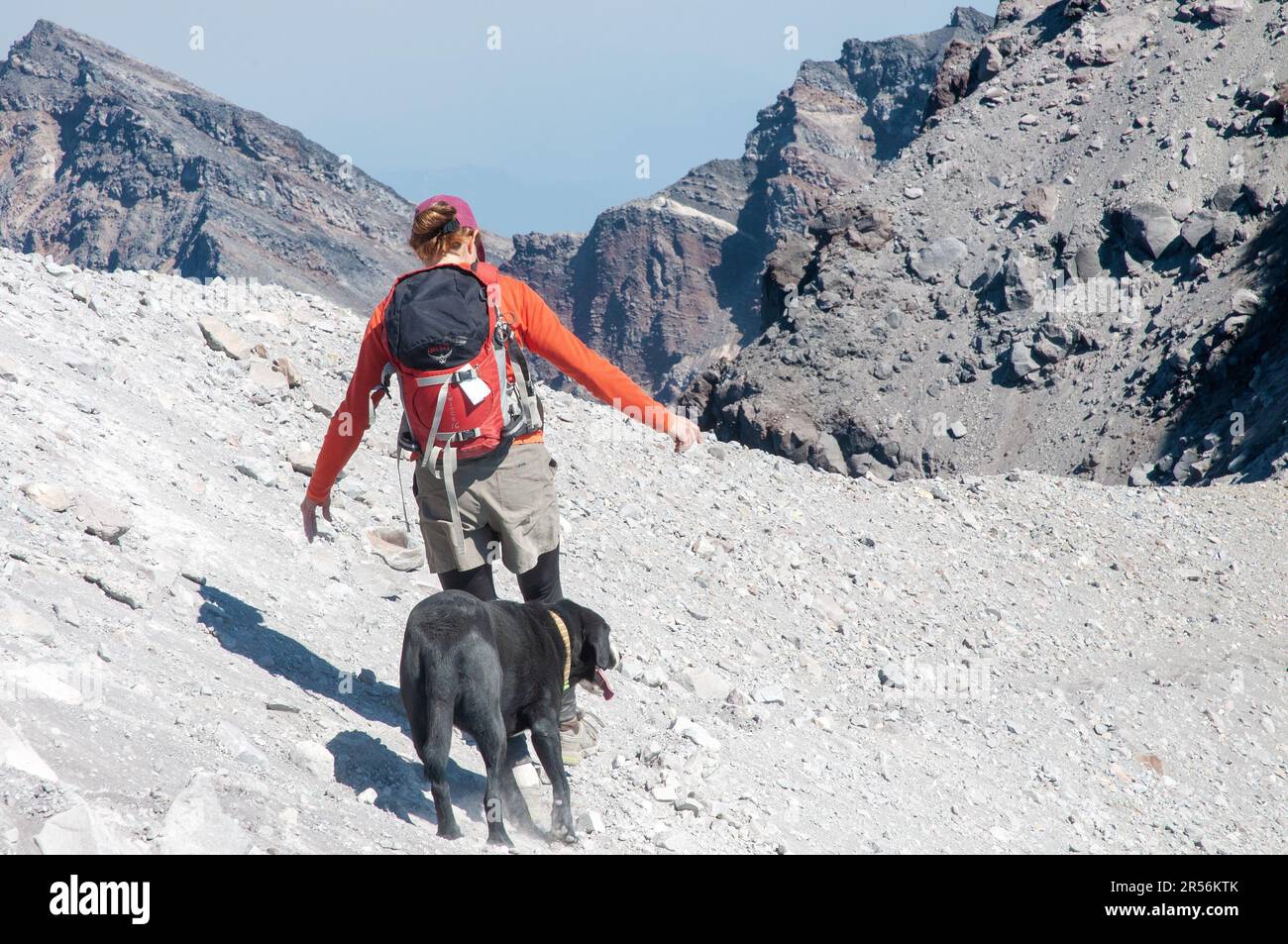 Donna con cane che scende da Mount Saint Helens, Washington state. STATI UNITI Foto Stock