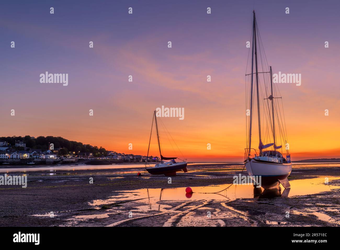 Instow Beach l'ultimo giorno di maggio. Il bagliore del tramonto si approfondisce di colore prima di sbiadire in blu, come attraverso l'estuario del fiume Torridge, le luci Foto Stock