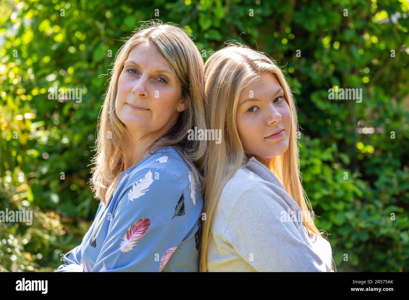 Madre e figlia adolescente di nuovo a schiena, combattendo Foto Stock