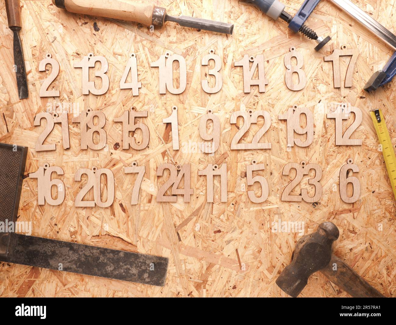 Numeri di legno da uno a ventiquattro come calendario di Avvento su un pannello OSB, legno o Falegnameria officina, Natale Foto Stock