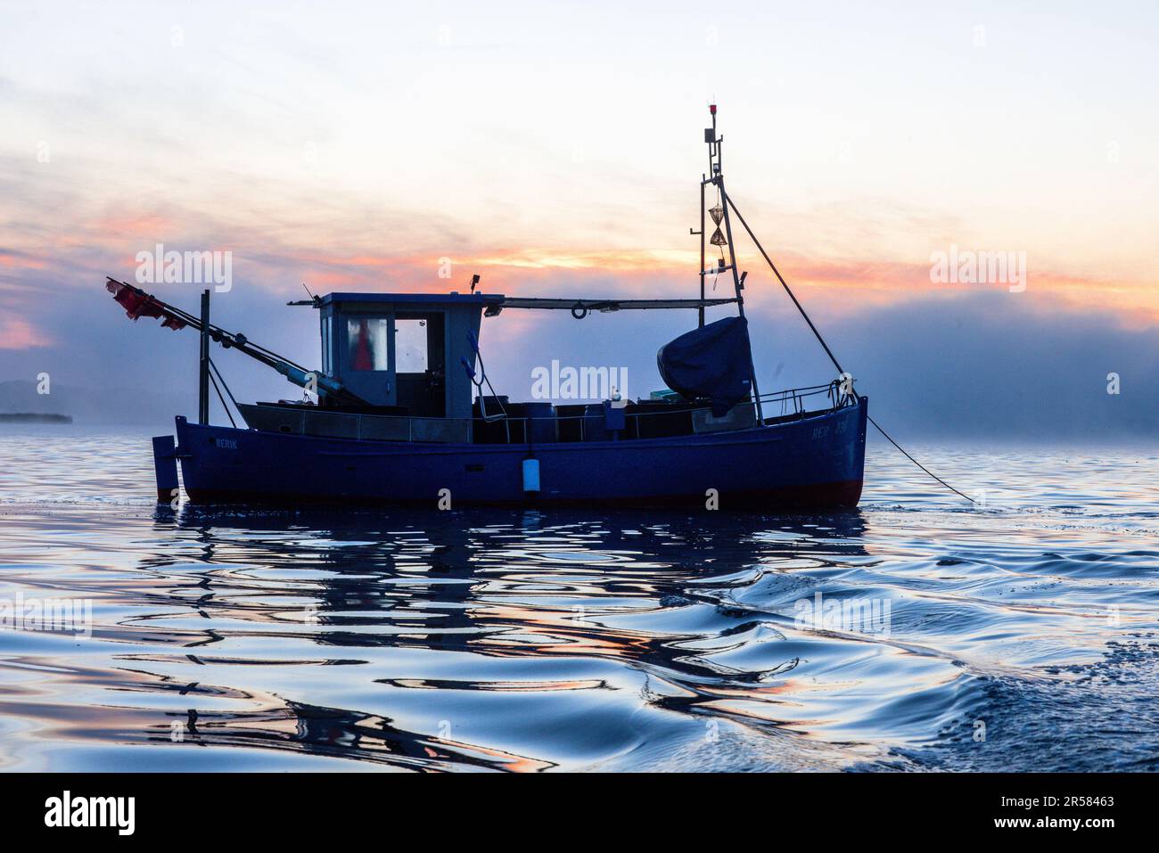 Rerik, Germania. 31st maggio, 2023. Fischer non si aggira mai sul Salzhoff prima dell'alba. Con una piccola barca, il pescatore guida verso le sue reti da traino in cui vengono catturati i granchi del Mar Baltico. Da tempo immemorabile, i granchi femminili migrano all'inizio di giugno nel Salzhoff tra Wismar e Rerik per riprodursi in direzione del Mar Baltico aperto. E' l'unico luogo della costa baltica dove i crostacei sono ancora oggi catturati. Soprattutto i buongustai locali apprezzano i freschi granchi del Mar Baltico, ma le loro catture sono minime rispetto al Mare del Nord. Credit: Jens Büt/dpa/Alamy Live News Foto Stock