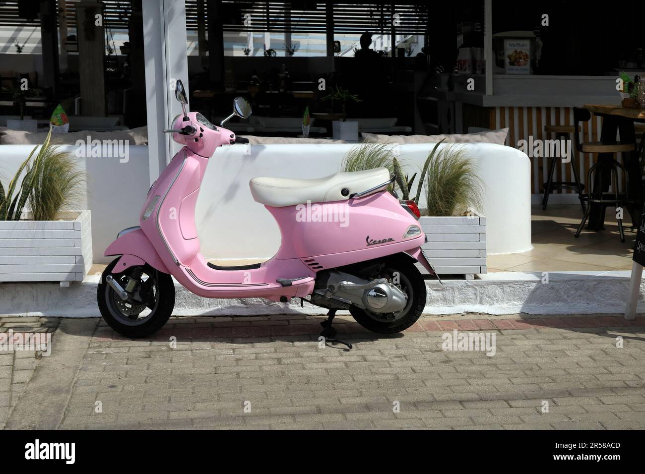 Scooter a motore Vespa rosa parcheggiato sulla strada, Isola di Agistri, Golfo Saronico, Grecia. Preso il 2023 maggio Foto Stock