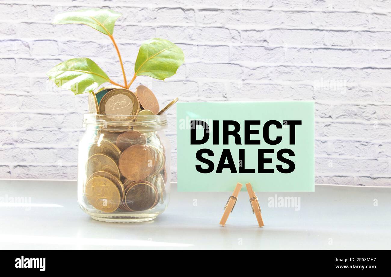 Concetto di business e finanza. Su sfondo rosso, ingranaggi e un piano di pensiero con l'iscrizione - VENDITE DIRETTE Foto Stock