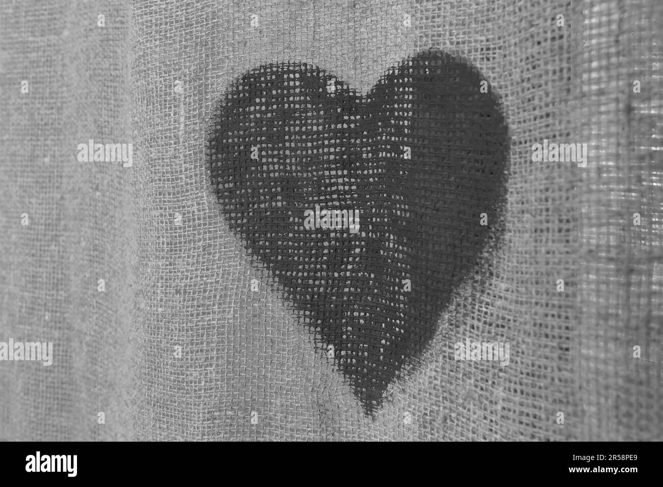 Un cuore nero scuro è un segno e un simbolo dell'amore deceduto passato su uno sfondo grigio. Foto Stock