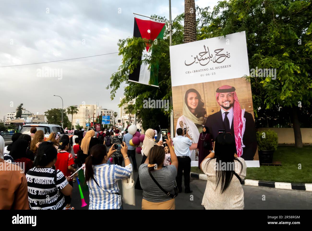 Gente felice che scatta le foto davanti al banner con il matrimonio di Hussein, il principe ereditario di Giordania e Rajwa al Saif. Giugno 1, 2023. Amman Giordania Foto Stock