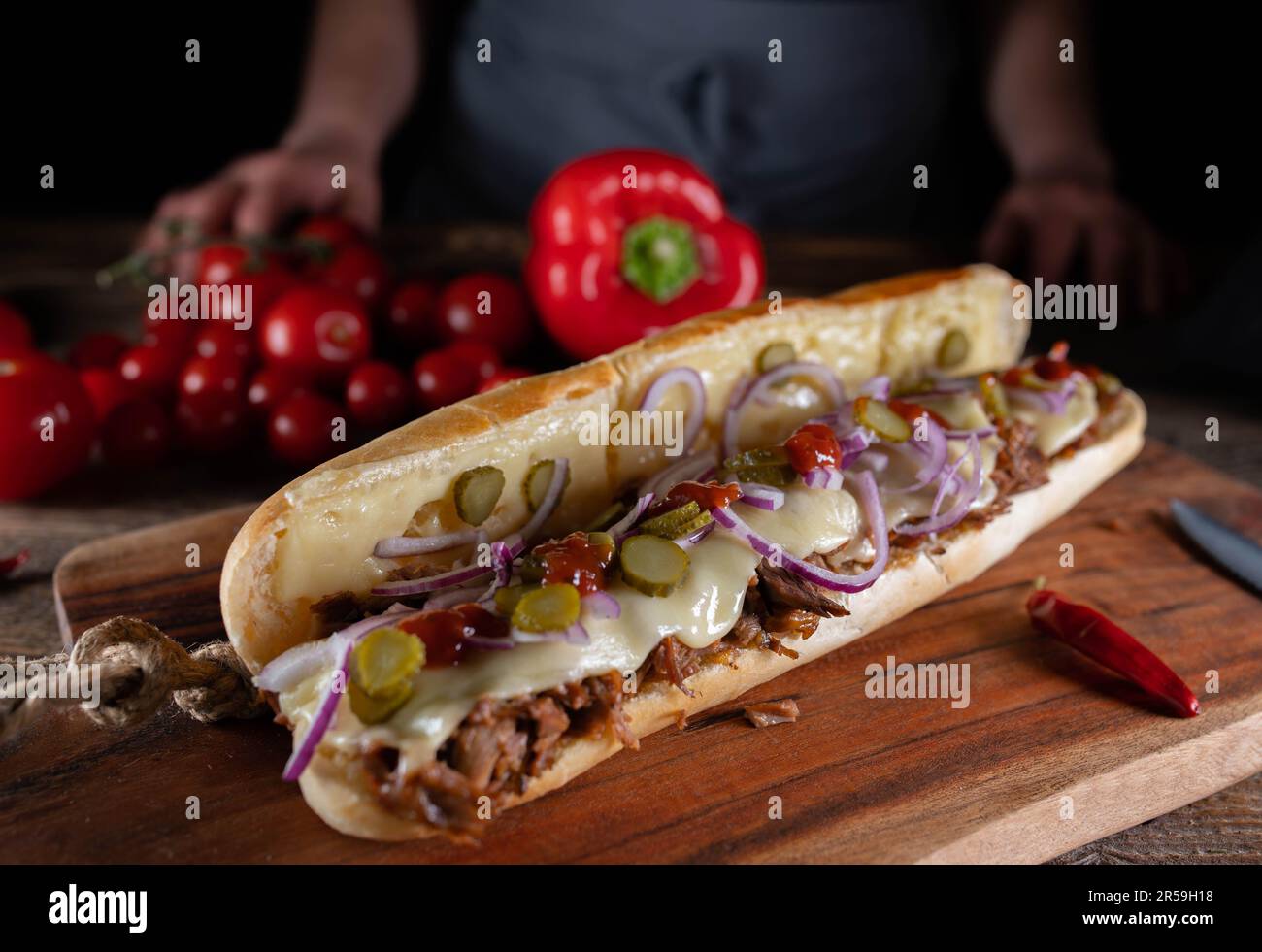 Panino sottomarino con carne di tacchino tirato, formaggio, sottaceti, cipolle e salsa al barbecue Foto Stock