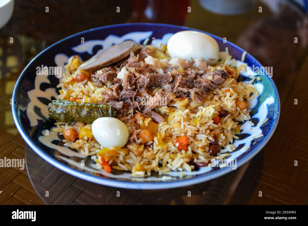 Plov piastra pilaf su sfondo nero. Cucina tradizionale uzbeka. Riso preparato con verdure e carne. Angolo superiore. Foto Stock